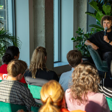 Kwebbelkop (Jordi van den Bussche) in gesprek met mbo-studenten en ondernemers uit Amsterdam-Noord.