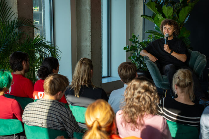 Kwebbelkop (Jordi van den Bussche) in gesprek met mbo-studenten en ondernemers uit Amsterdam-Noord.